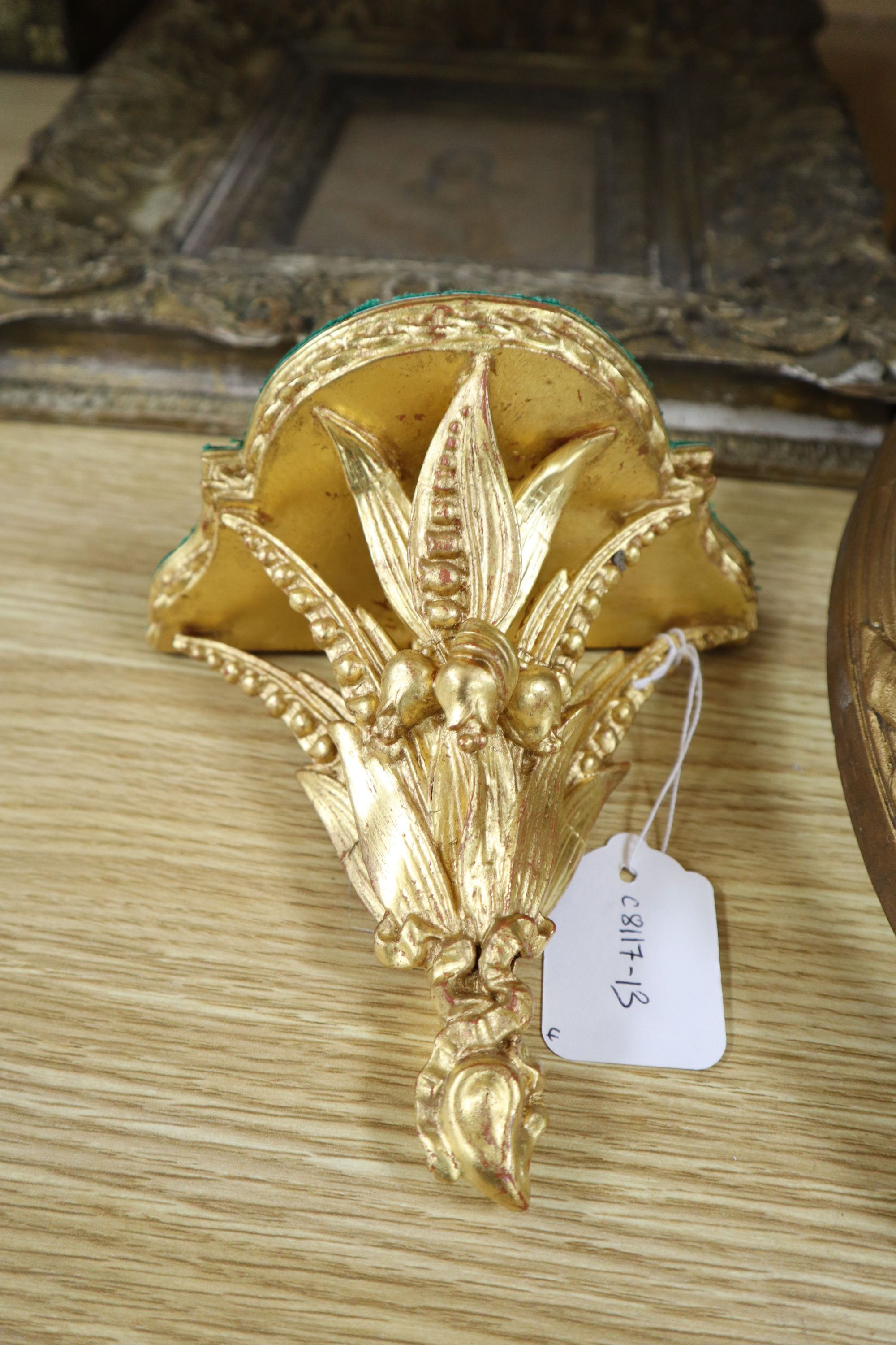 A pair of Victorian ornate gilt gesso oval picture frames, 50 x 55cm, a similar wall shelf and a picture